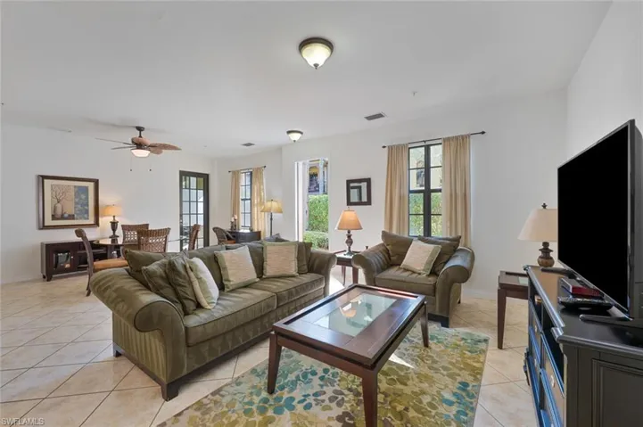 Living area with light tile patterned floors and a ceiling fan