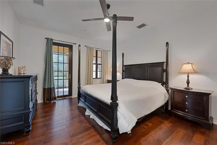 Bedroom featuring dark wood-type flooring, a ceiling fan, crown molding, and access to outside