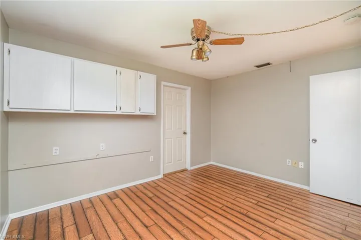 Unfurnished room with ceiling fan and wood-type flooring