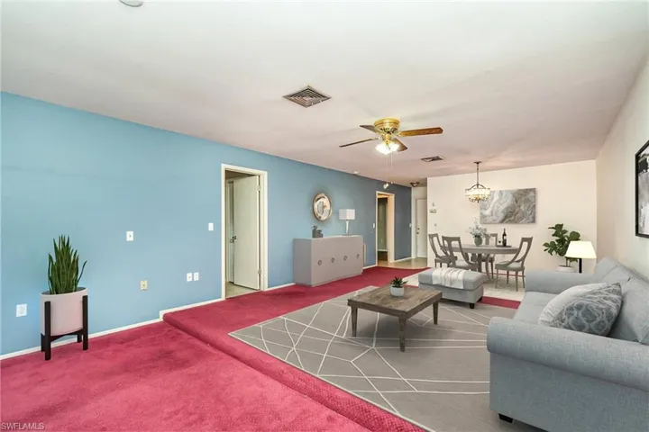 Carpeted living room with ceiling fan