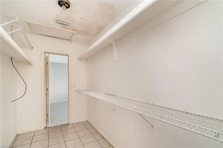 Spacious closet with light tile floors