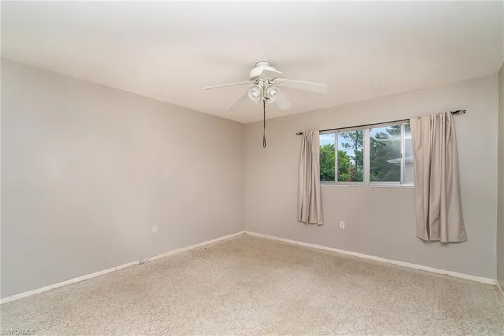 Carpeted spare room featuring ceiling fan