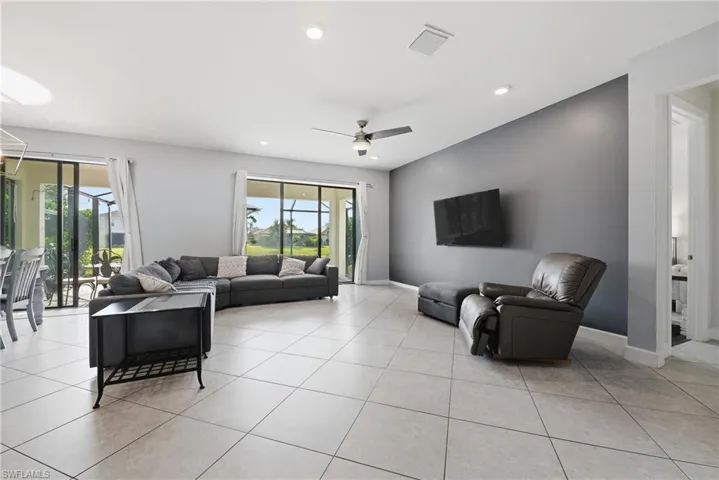 Open concept living area featuring light-toned tile flooring throughout and a contemporary ceiling fan