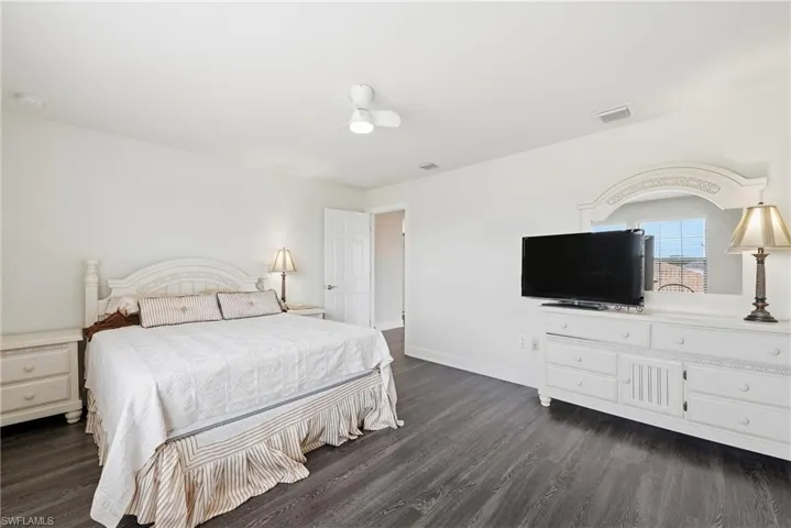Spacious room featuring dark wood-finish flooring and light-toned walls