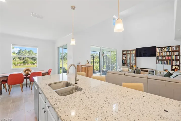Kitchen featuring plenty of natural light, sink, pendant lighting, and white cabinets