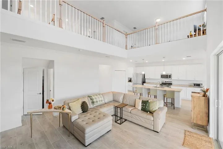 Living room with sink, a high ceiling, and light hardwood / wood-style floors