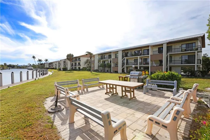 View of patio featuring a balcony, grilling area, and a water view