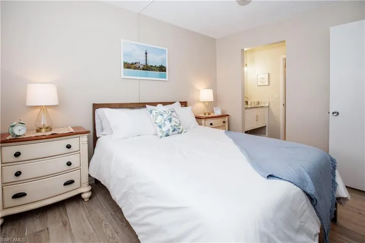 Bedroom featuring ensuite bath and wood-type flooring