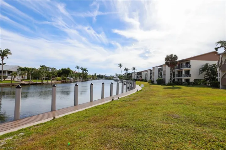 Dock area featuring a water view and a lawn