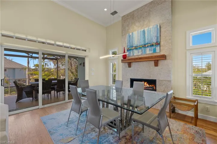 Dining space with ornamental molding, a fireplace, hardwood / wood-style floors, and plenty of natural light