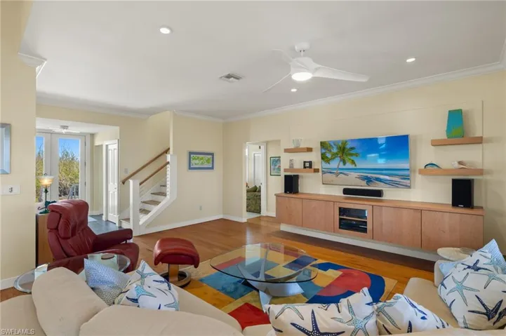 Living room featuring crown molding, ceiling fan, and light hardwood / wood-style floors
