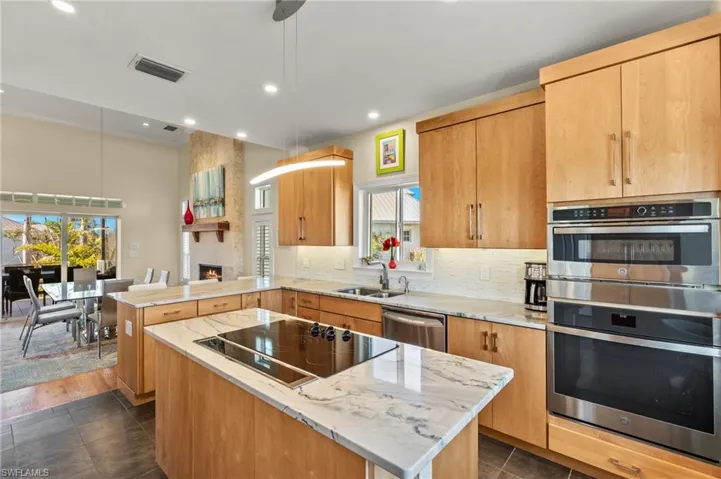 Kitchen with a kitchen island, decorative light fixtures, sink, kitchen peninsula, and stainless steel appliances