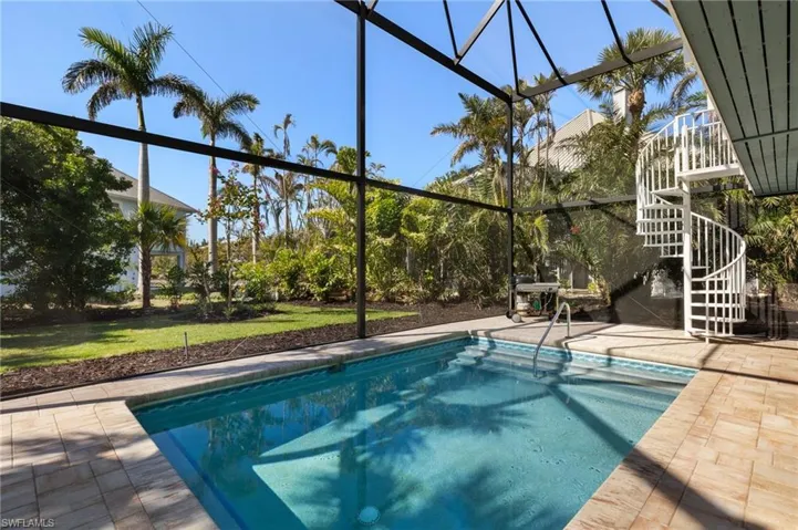 View of swimming pool with a patio, glass enclosure, and a lawn