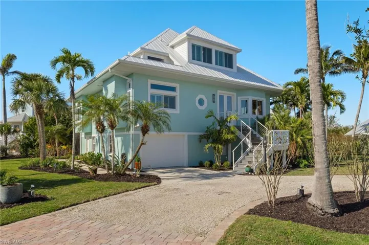 Coastal home with a garage and a front lawn