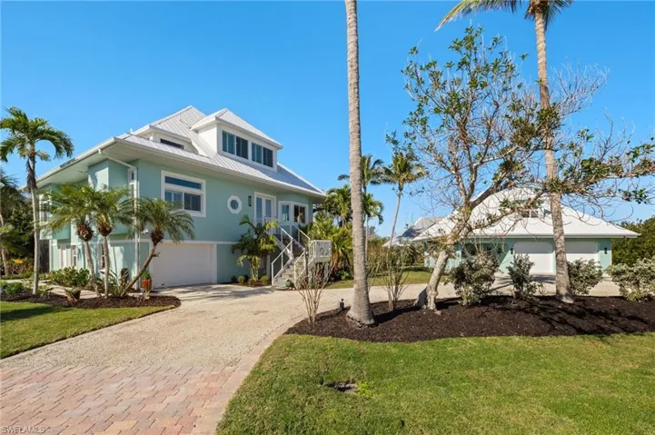 View of front of property with a garage and a front lawn