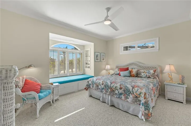 Carpeted bedroom with crown molding and ceiling fan