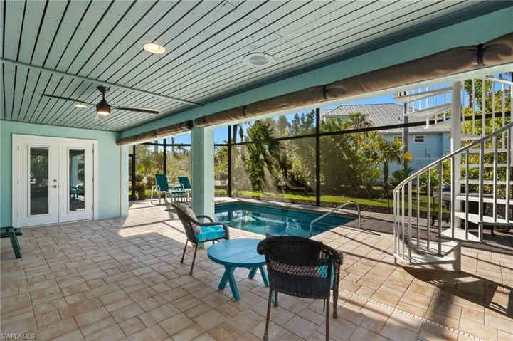 View of swimming pool featuring french doors, ceiling fan, and a patio area