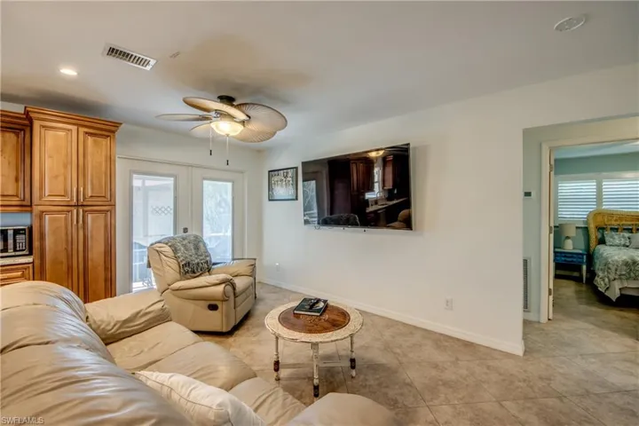 Living room featuring french doors, a ceiling fan, recessed lighting, and light tile patterned floors