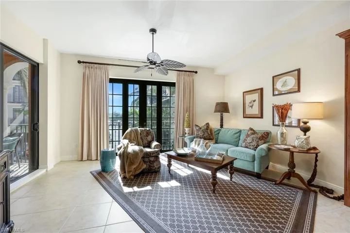 Living room featuring ceiling fan, french doors, and light tile patterned flooring