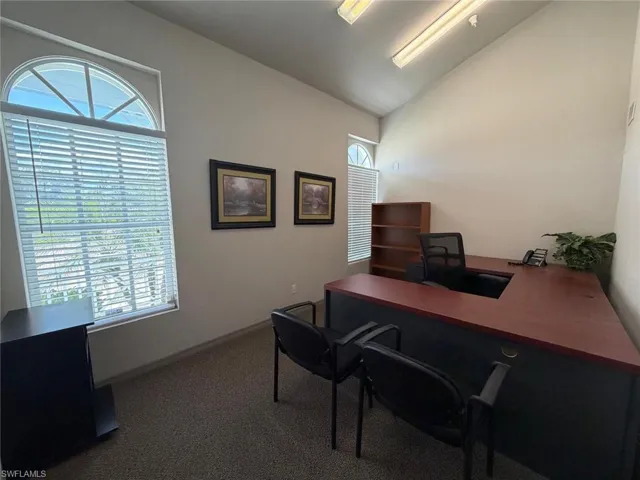 Office space featuring vaulted ceiling