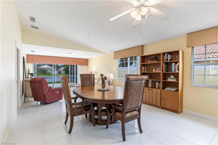 Tiled dining space featuring vaulted ceiling and ceiling fan