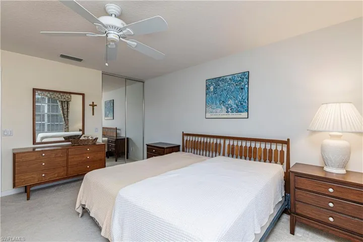Carpeted bedroom featuring ceiling fan, a closet, and a textured ceiling