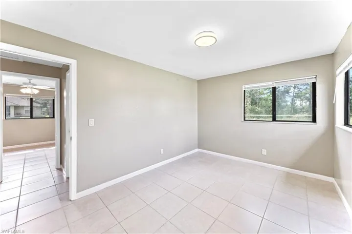 Empty room featuring ceiling fan and light tile patterned floors