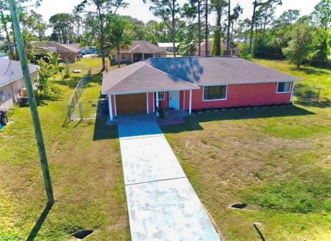 Ranch-style home featuring a front lawn and a garage