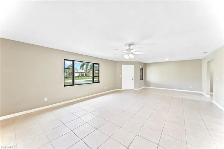 Empty room with light tile patterned flooring and ceiling fan