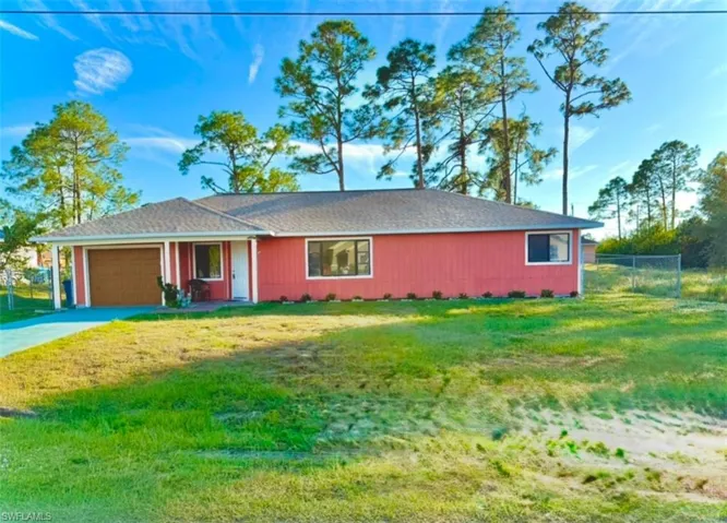 Single story home featuring a garage and a front lawn