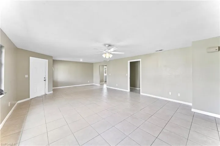 Empty room featuring light tile patterned floors and ceiling fan
