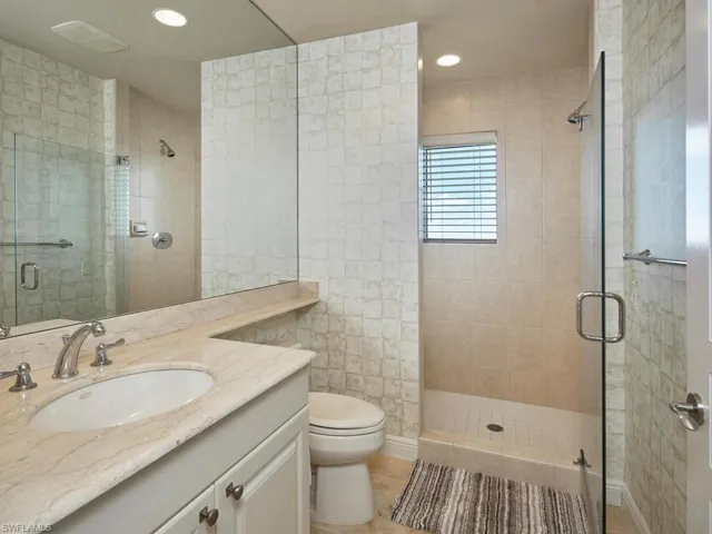 Full bath with vanity, a shower stall, recessed lighting, and light tile patterned flooring