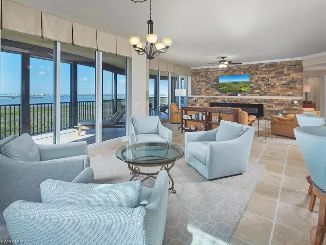 Living room with a chandelier, a water view, and ceiling fan
