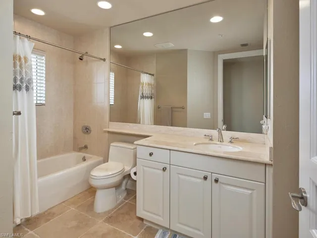Bathroom with light tile patterned floors, shower / bathtub combination with curtain, vanity, and recessed lighting
