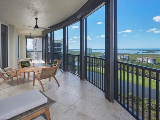 Sunroom with floor to ceiling windows, a water view, a textured ceiling, and tile patterned flooring