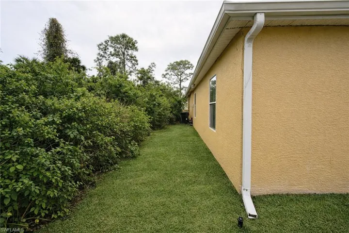 View of property exterior with stucco siding and a yard