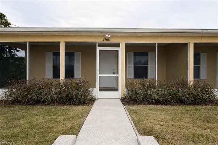 Entrance to property featuring stucco siding and a yard