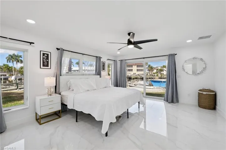 Bedroom with light marble finish flooring, access to exterior, ceiling fan, and recessed lighting