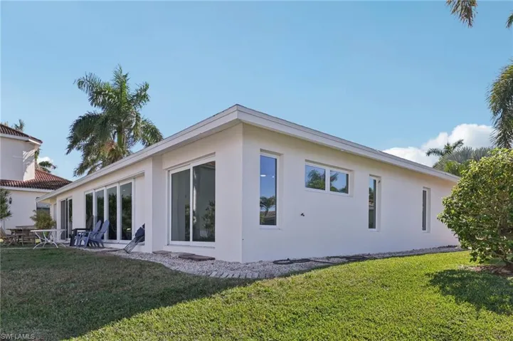 Back of property with a lawn, stucco siding, and a patio