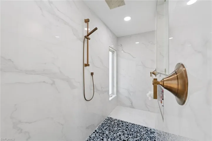 Full bathroom with a marble finish shower and recessed lighting