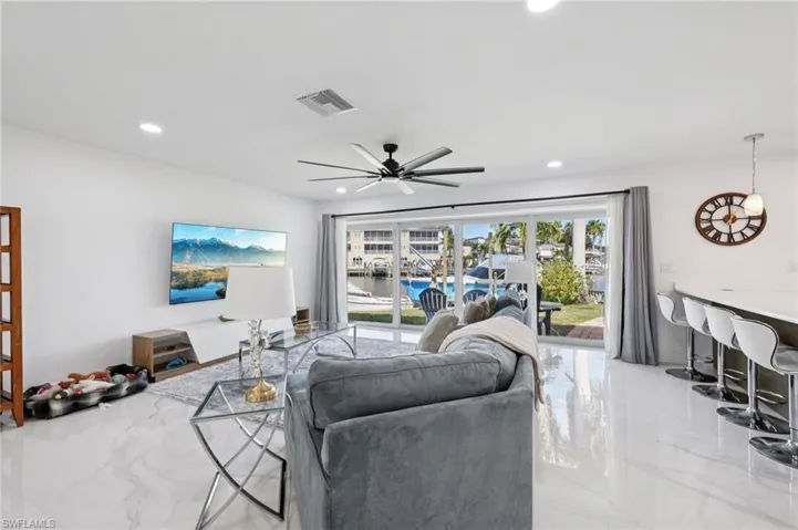 Living room with light marble finish floors, a ceiling fan, and recessed lighting