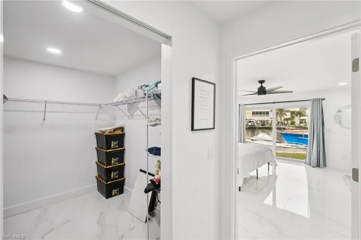 Spacious closet featuring light marble finish flooring and ceiling fan