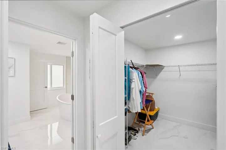 Walk in closet with light marble finish flooring