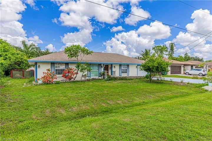 Ranch-style home with a garage and a front lawn