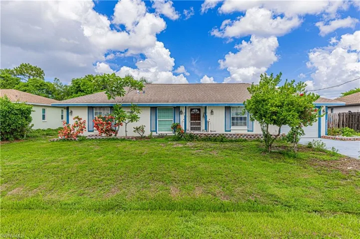 Ranch-style house featuring a garage and a front yard