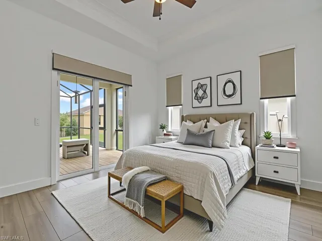 Bedroom with wood finished floors, access to exterior, a tray ceiling, a ceiling fan, and ornamental molding