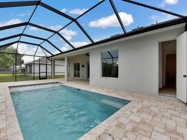 Swimming pool with a sunroom, a patio, glass enclosure, and a ceiling fan