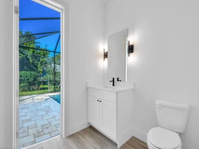Half bathroom with light wood-style floors and vanity