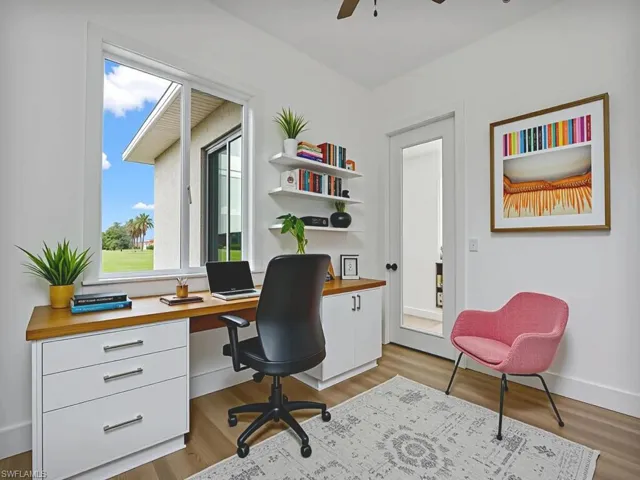 Office featuring dark wood finished floors, a ceiling fan, and built in study area