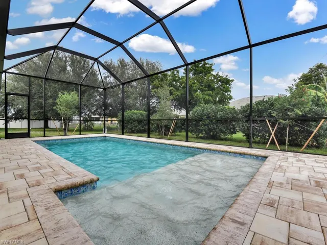 Swimming pool with a sunroom, glass enclosure, and a patio area